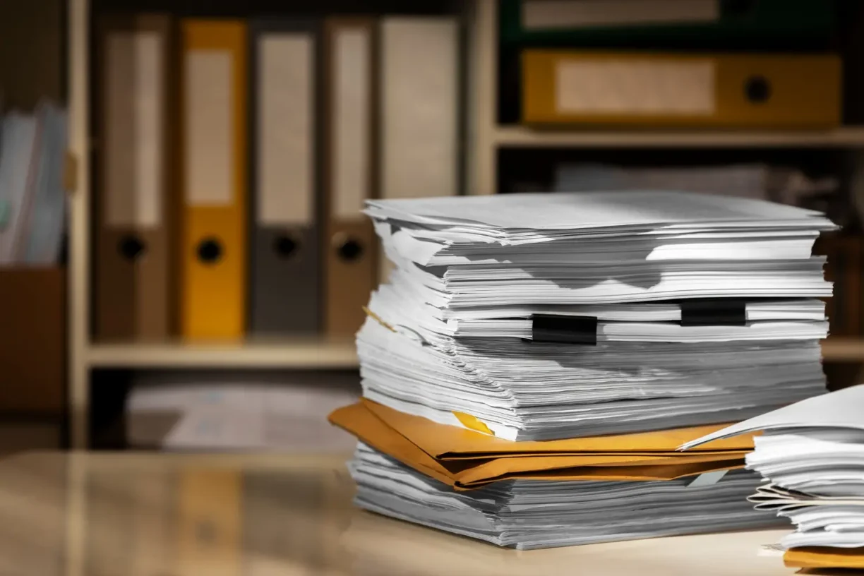 Close-up of a stack of paperwork and folders in an office setting, lemonmyvehicle