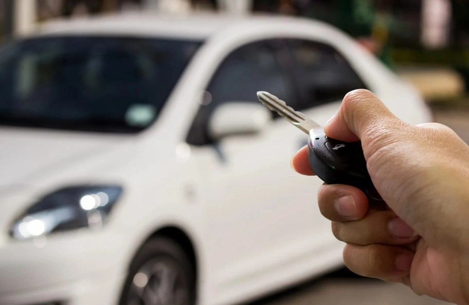 A car salesman handing keys to a customer, depicting a vehicle transaction that could lead to a Lemon Law claim if the car is defective.
