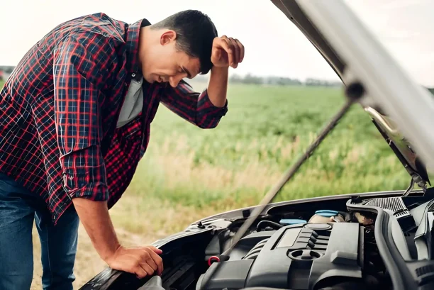 Frustrated driver checking engine breakdown showing lemon law vehicle issues