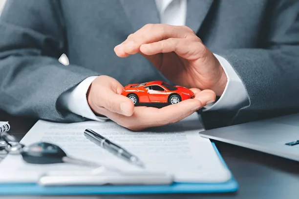 Car keys and coins beside red car model symbolizing lemon law compensation