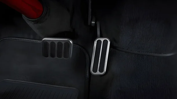 Close-up view of a car’s brake and accelerator pedals inside a modern vehicle interior.