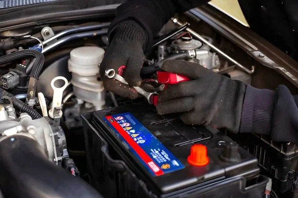 Mechanic inspecting a faulty car battery that could signal a Lemon Law eligible defect