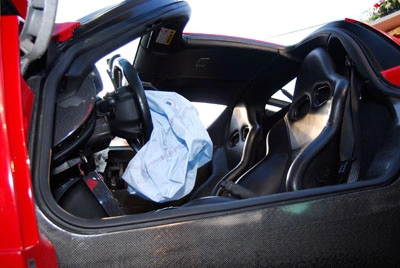 Interior view of a vehicle showing a deployed airbag on the driver’s side, illustrating airbag safety system activation after a collision.