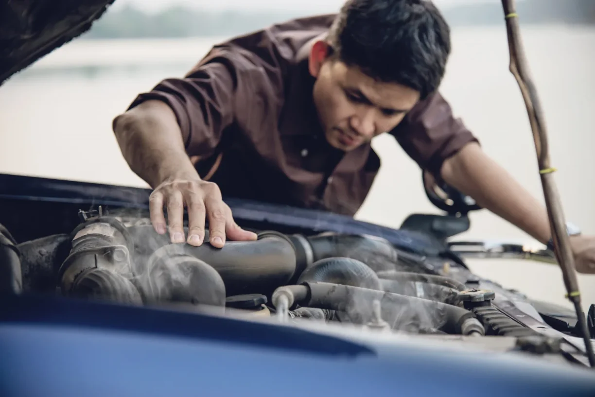 Mechanic inspecting overheating car engine for potential lemon law claim