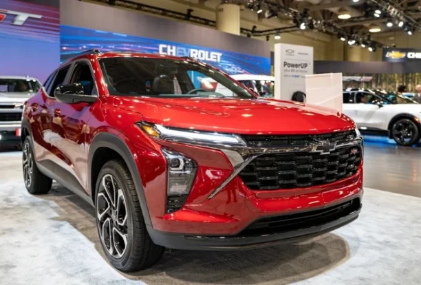 Red Chevrolet SUV displayed at an auto show, highlighting modern front grille design, advanced safety features, and updated exterior styling.