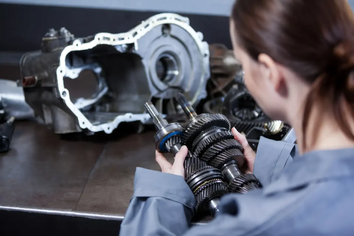Technician inspecting transmission components related to recurring defects in lemon law vehicle cases