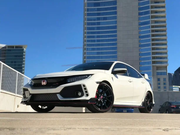 White Honda parked in the city representing a vehicle with potential defects covered by lemon laws.