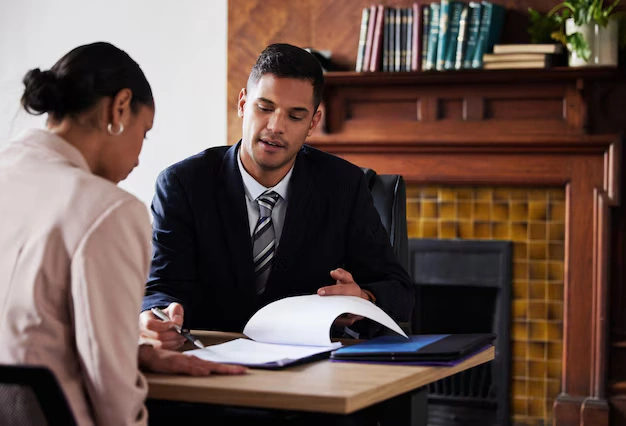 Lemon law attorney reviewing documents with a client during a legal consultation about defective vehicle claims and warranty rights.