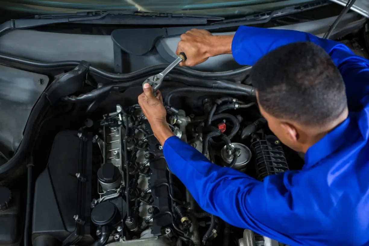Mechanic inspecting and repairing car engine components under the hood