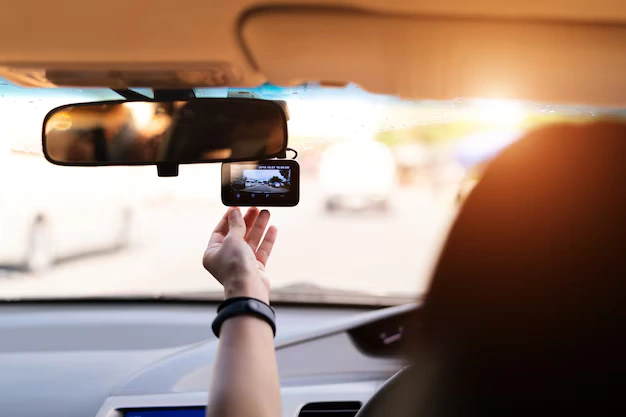 Driver adjusting dashcam to document 2022 RAM 1500 problems as evidence for a lemon law claim