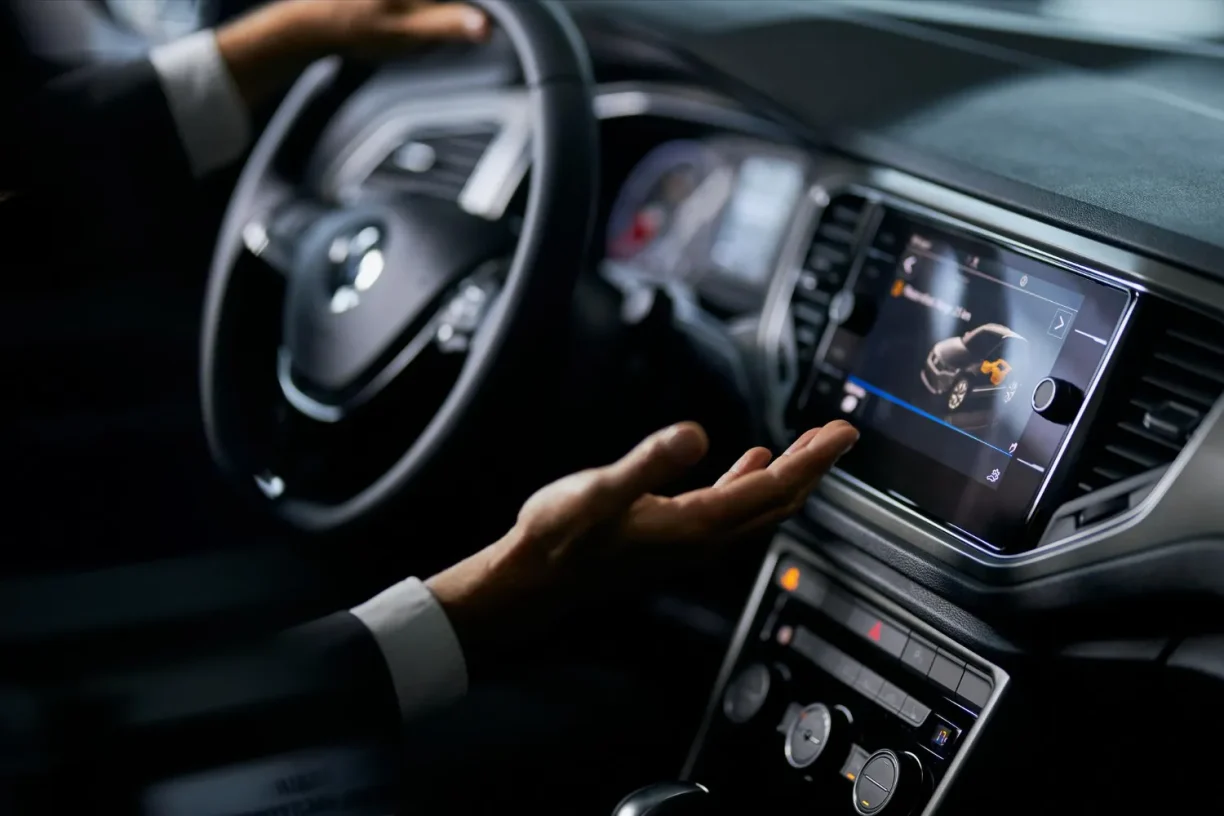 Driver interacting with infotainment touchscreen displaying one of the common 2023 Honda Pilot problems including electrical and sensor malfunctions