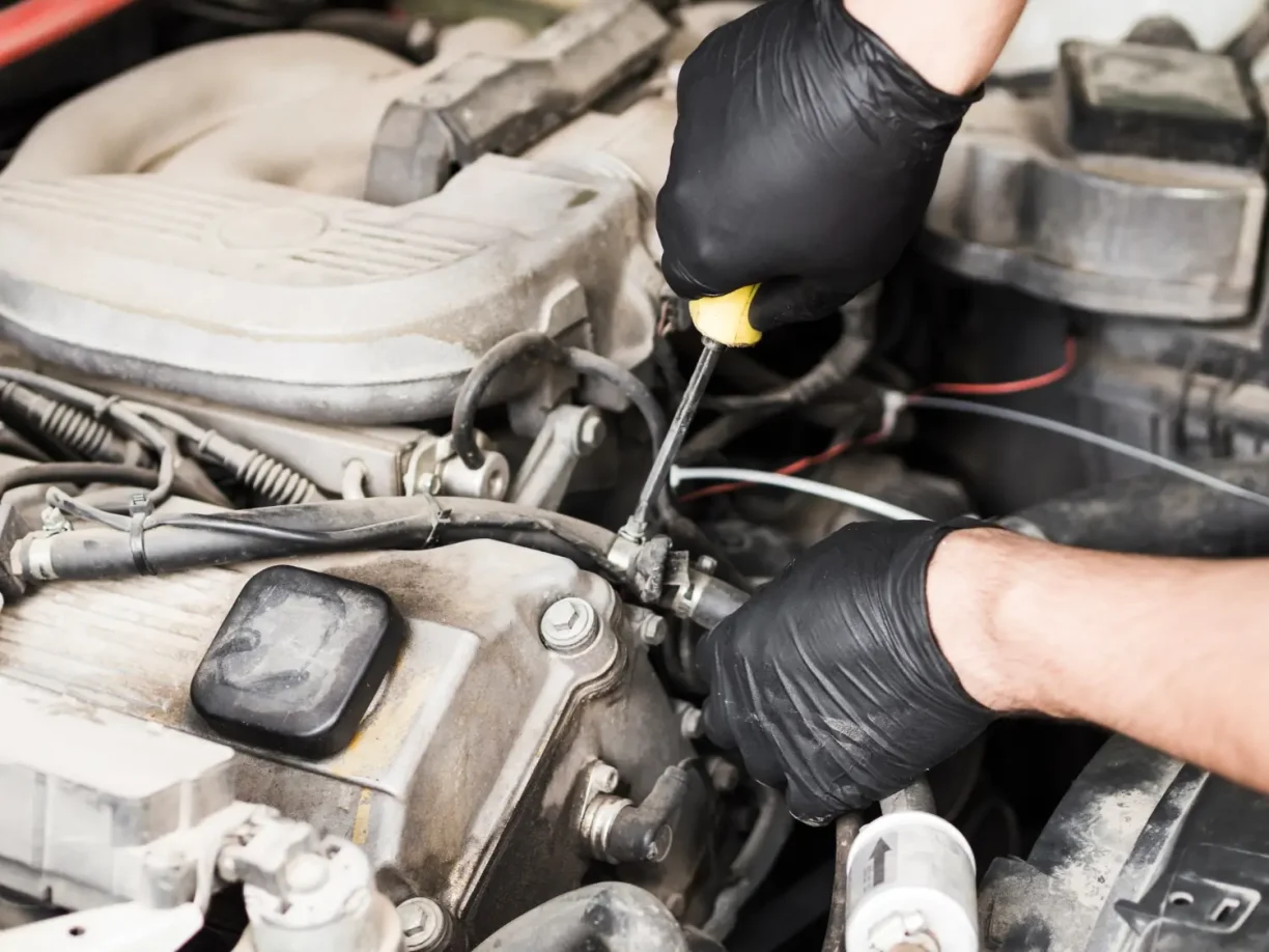 Mechanic diagnosing engine issues under the hood related to 2023 Honda Pilot problems that may qualify for a lemon law claim